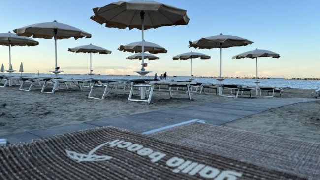 Spiaggia con ombrelloni e lettini.