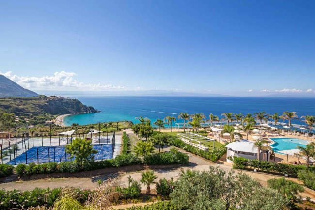 Resort con piscina e campi sportivi vista mare.