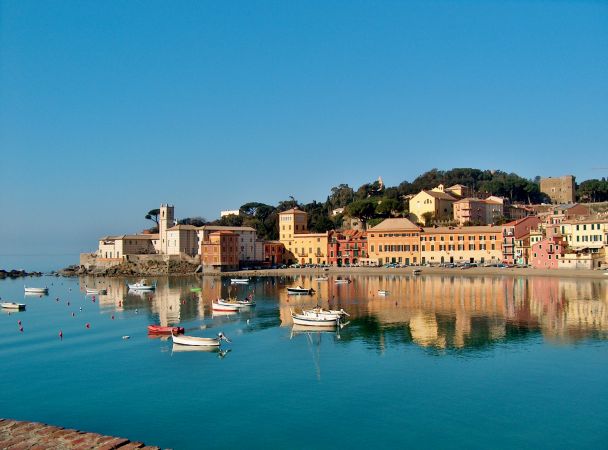 Baia con case colorate riflesse nell'acqua.