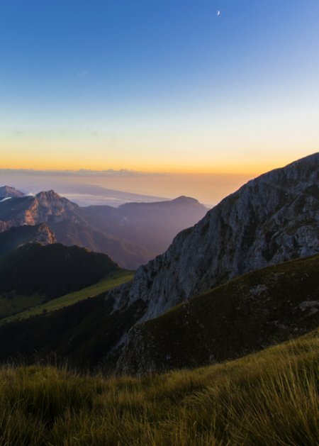 Paesaggio di montagna al tramonto, cielo limpido.