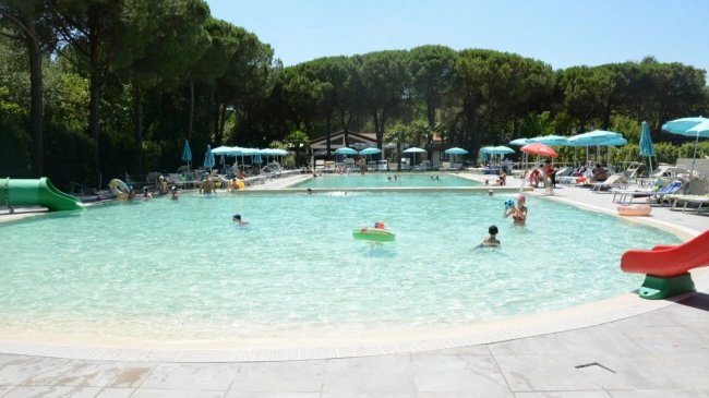 Piscina all'aperto con scivolo verde.