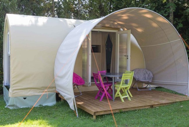 Tenda con patio, mobili colorati sul prato.