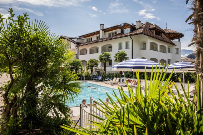 Piscina esterna accanto a un grande edificio.