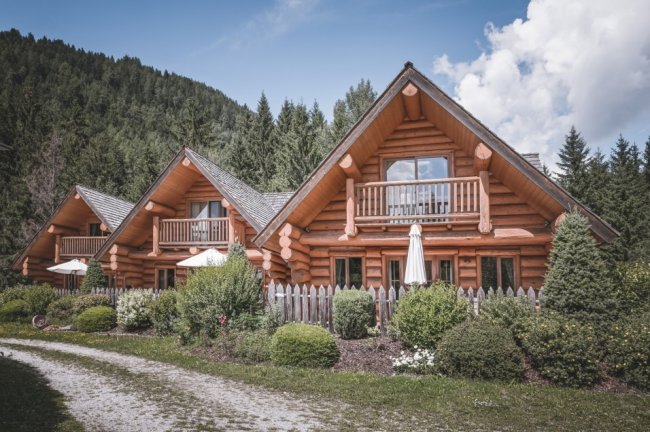 Chalet di legno con balconi immersi nel verde.