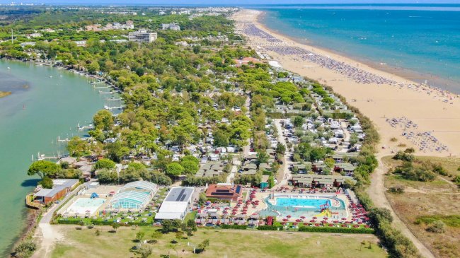Campeggio con piscine vicino a una lunga spiaggia sabbiosa.