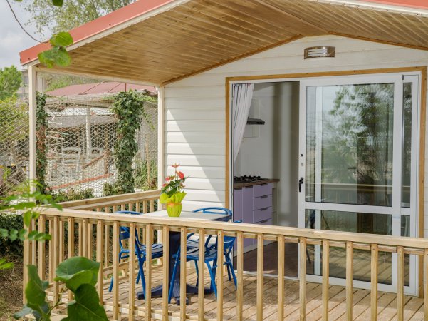 Veranda di legno con tavolino e sedie blu.