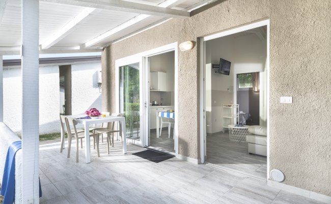 Veranda di una casa con tavolo da pranzo e accesso a un soggiorno accogliente.