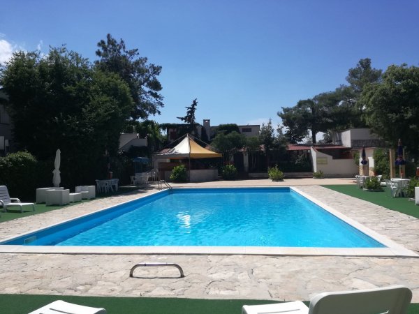 Una piscina all'aperto con sedie a sdraio e cielo sereno.