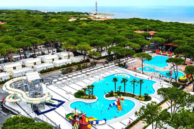 Piscina all'aperto con scivoli e lettini.