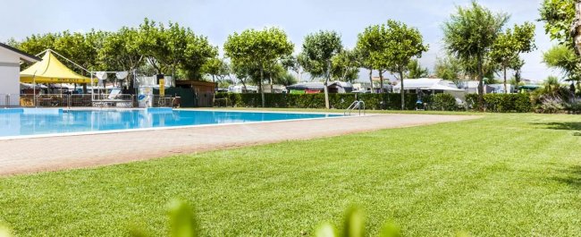 Piscina all'aperto con prato verde.