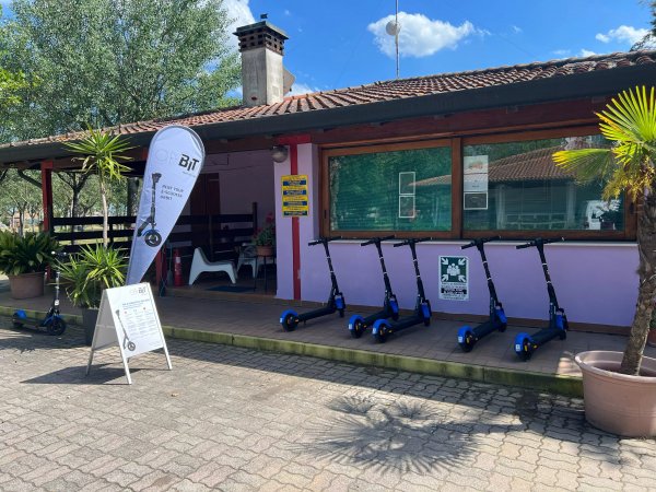 Noleggio monopattini accanto a un edificio viola.