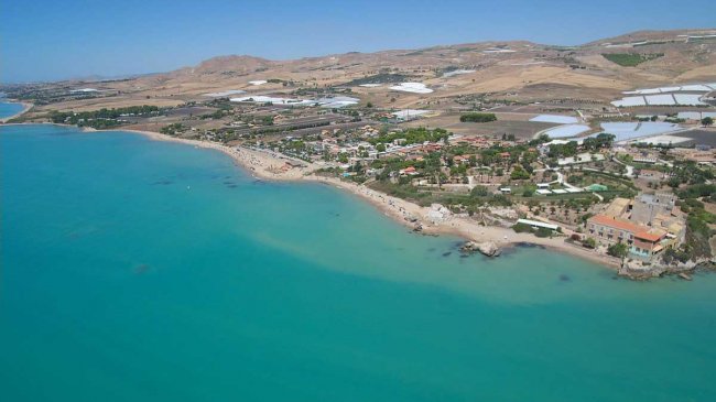Vista aerea di una spiaggia con mare turchese.