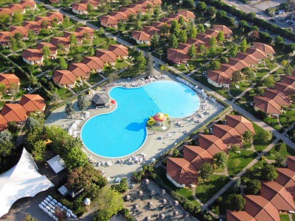 Grande piscina circondata da bungalow.