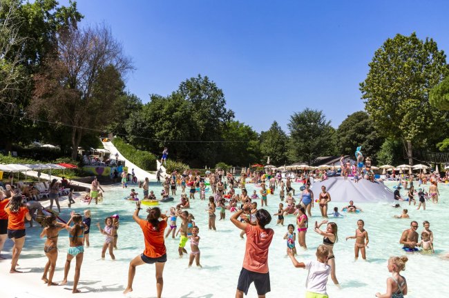 Persone che si divertono in una piscina affollata.